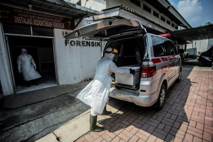 Health officials in Indonesia prepare a coffin as Covid deaths soar in the Southeast Asian country