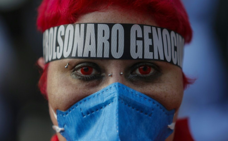 A woman wearing a headband denouncing Brazilian President Jair Bolsonaro as 'genocidal' for his handling of the pandemic takes part in a protest in Sao Paulo on July 3, 2021