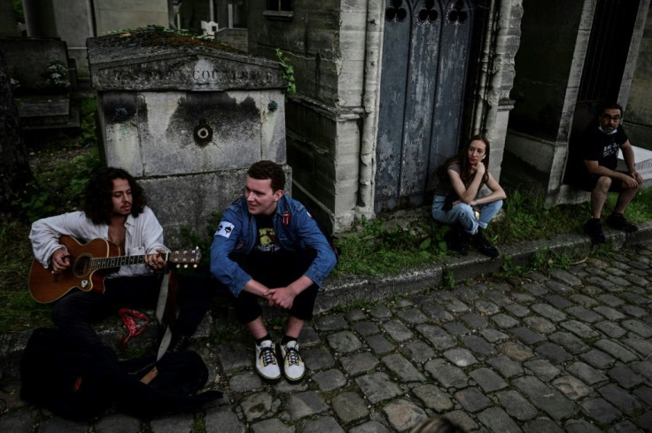 Marius de la Brosse (L) whipped out his guitar to entertain other fans gathered at the grave