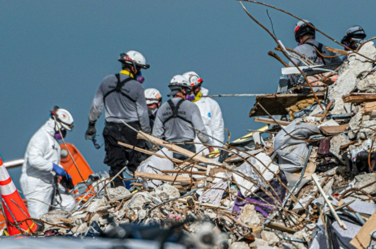 Workers searching the site of a collapsed condo in Surfside, Florida, on July 2, 2021; with a storm approaching, the part of the structure still standing will quickly be razed