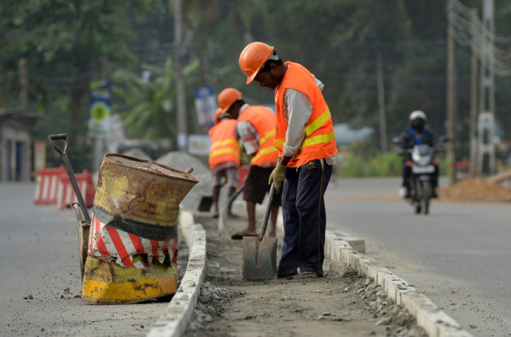 Sri Lankan construction labourers work on a road in Colombo
