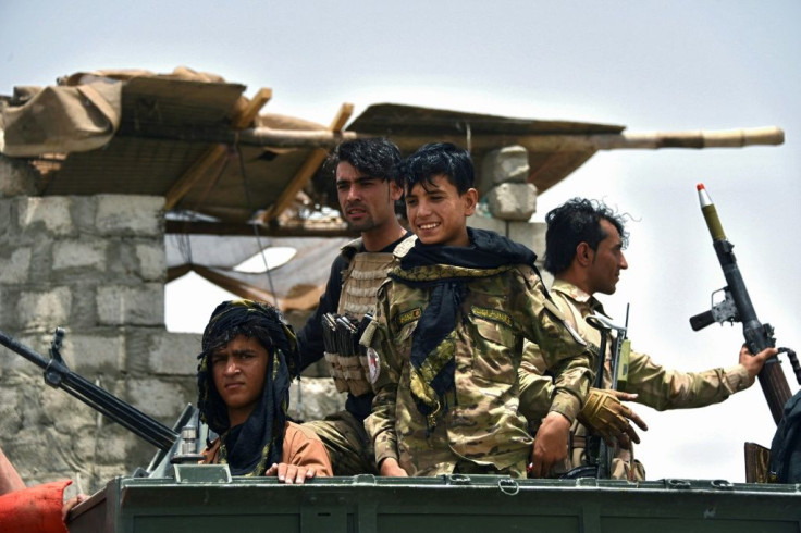 Afghan policemen sit on an armored vehicle at a checkpoint in Panjwai district of Kandahar province