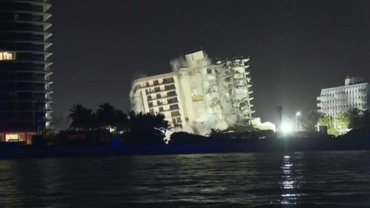 A controlled explosion brought down the unstable remains of the collapsed apartment block in Florida ahead of a threatening tropical storm, with the confirmed death toll at 24 and 121 people missing.