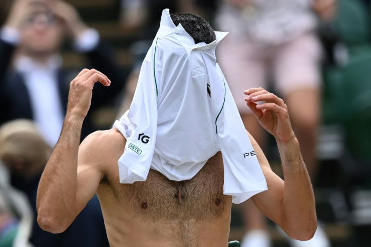 All change: Novak Djokovic changes his shirt during a break in play against Chile's Cristian Garin