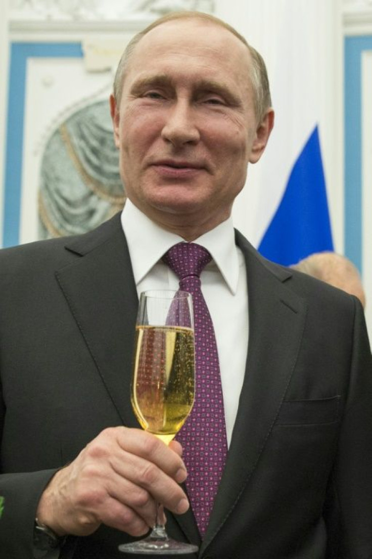 Russian President Vladimir Putin holds a glass of bubbly in 2016