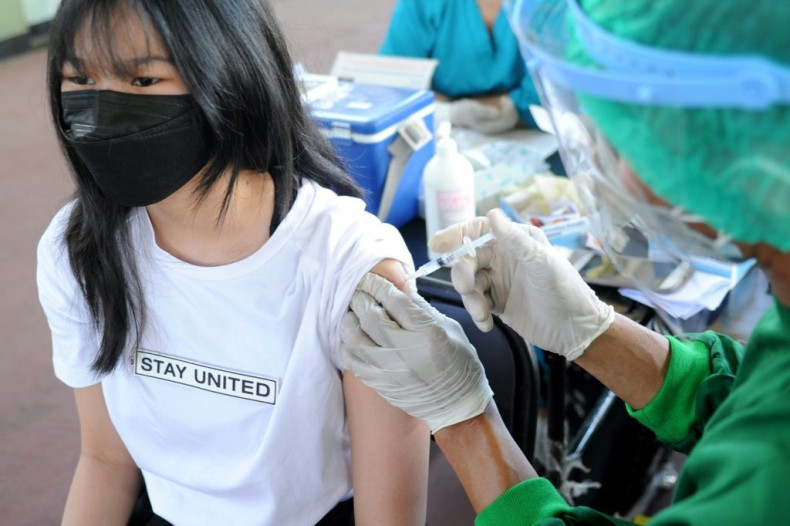 A young woman receives the AstraZeneca Covid-19 coronavirus vaccine at a makeshift mass vaccination clinic on Indonesia's resort island of Bali