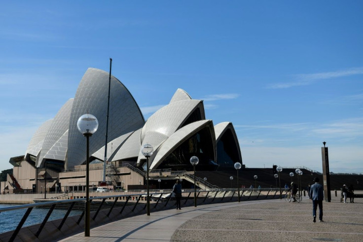 People walk through an unusually quiet Sydney Opera House forecourt in Sydney, as the city remains in lockdown for a second week