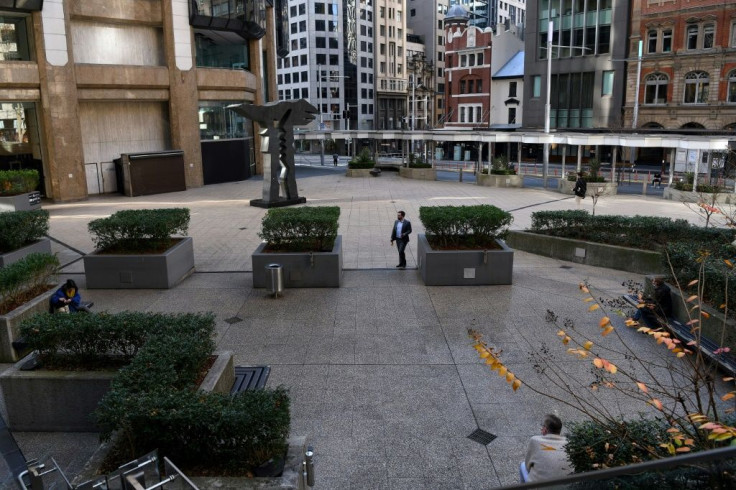 People sit in a quiet plaza in the central business district in Sydney, as the city remains in lockdown for a second week to contain an outbreak of the highly contagious Delta Covid-19 variant