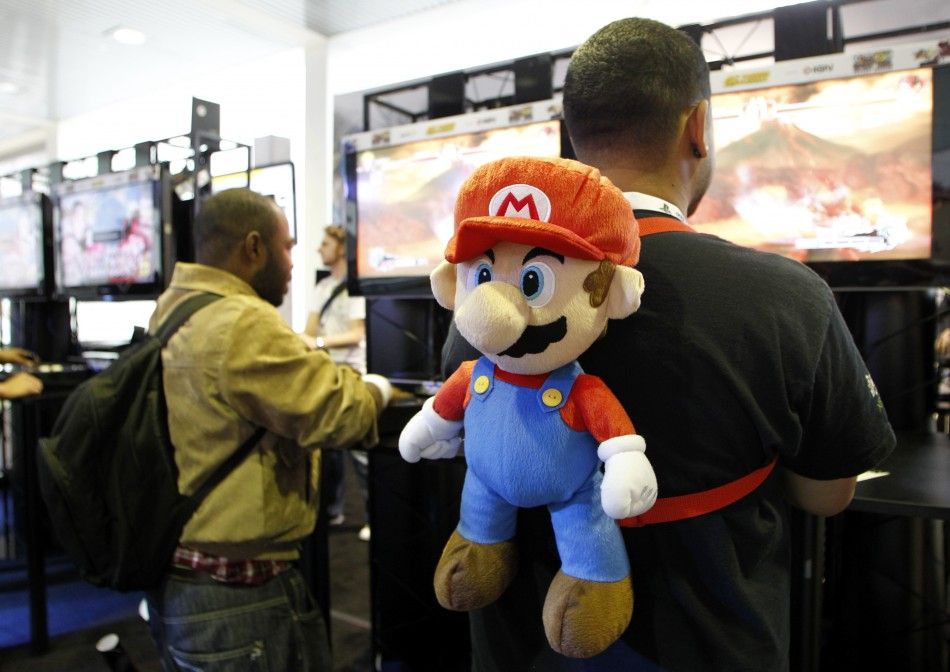 A gamer wears a Super Mario backpack as he plays a game during E3 in Los Angeles