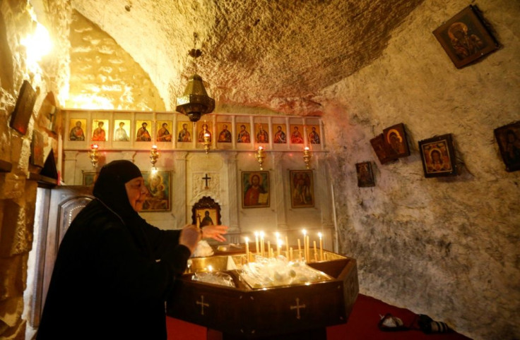 A nun lights candles in the Syrian village of Maalula, in of the world's oldest Christian settlements