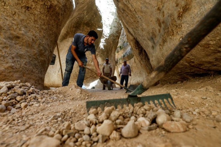 In the narrow pass at the foot of the canyon, men have been working in the summer heat to prepare the site for visitors