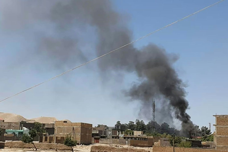 A smoke plume rises from houses as clashes rage between Afghan security forces and Taliban fighters in the western city of Qala-i-Naw in Afghanistan