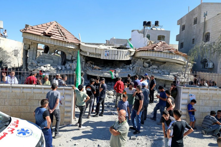 Palestinian villagers in the Israeli-occupied West Bank inspect the remains of the home of a US dual national, demolished by Israeli troops overnight to punish her estranged husband, who is accused of fatally shooting a Jewish student