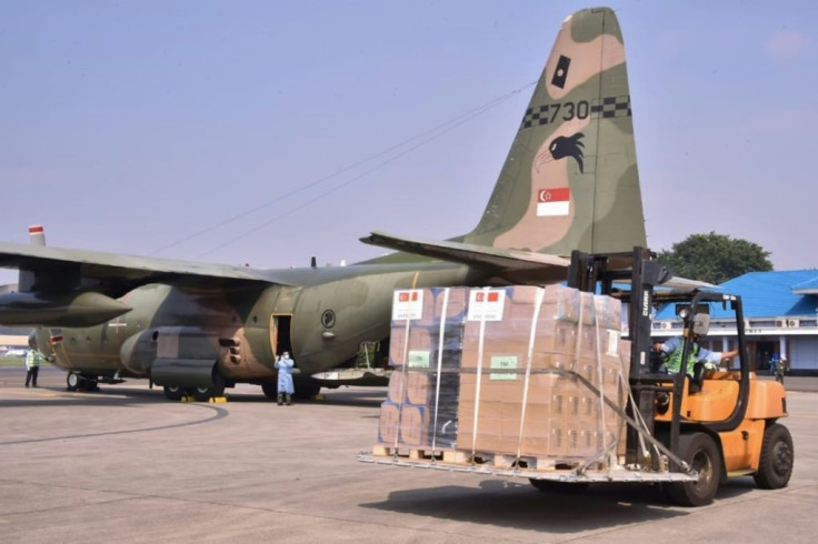 Staff at an air base in Jakarta unload medical equipment from two Singaporean air force planes
