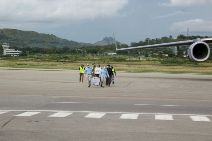 Australian officials carry boxes containing 8,000 doses of the AstraZeneca vaccine following their arrival in Port Moresby in March