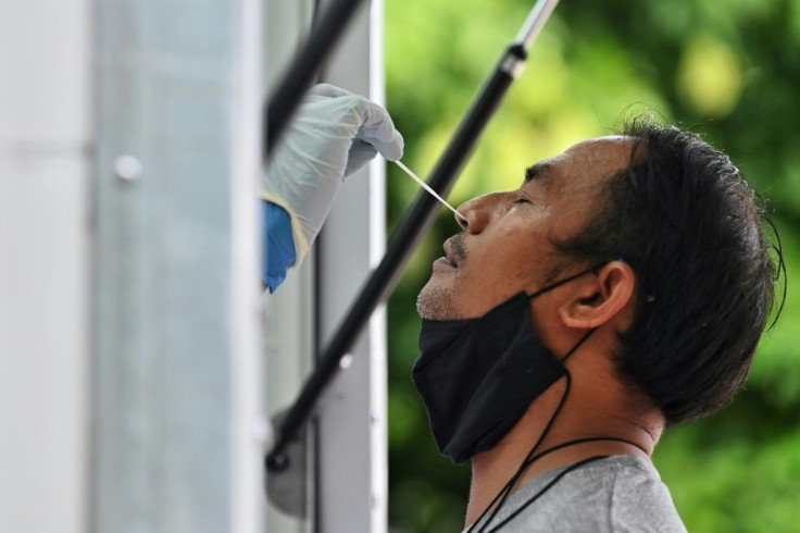 Health workers administer coronavirus tests from a mobile clinic in Bangkok