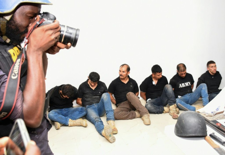 Police paraded some of the suspects before the media Thursday, along with Colombian passports and weapons they had seized