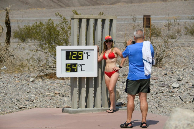 Tourists pose next to a thermometer in California's Death Valley in June. Sweltering conditions have hit much of the Pacific seaboard and as far inland as the western edge of the Rocky Mountains over the weekend