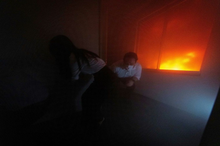Visitors to the Ikebukuro Life Safety Learning Centre try to find an exit door during a fire simulation
