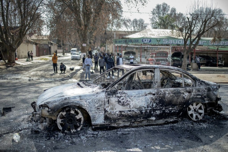 Violence: A burned-out car in Johannesburg's Jeppestown district