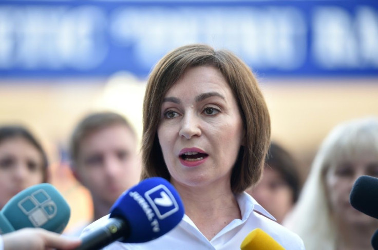 Moldovan President Maia Sandu speaks with journalists outside a polling station during parliamentary elections in Chisinau