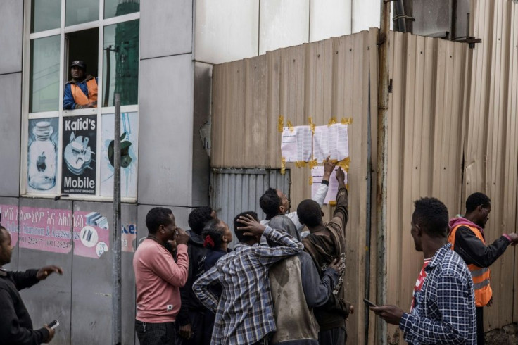 Ethiopian voters look at polling station tallies posted outside a station in Addis Ababa on June 22, 2021