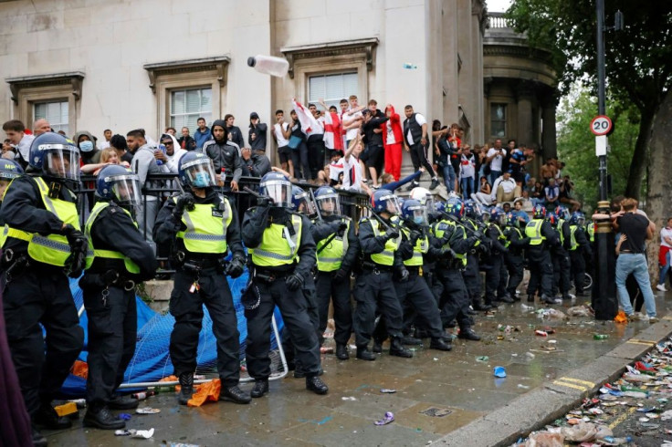 Police officers monitor England supporters standing on the edge of Trafalgar Square during a live screening of the UEFA EURO 2020 final