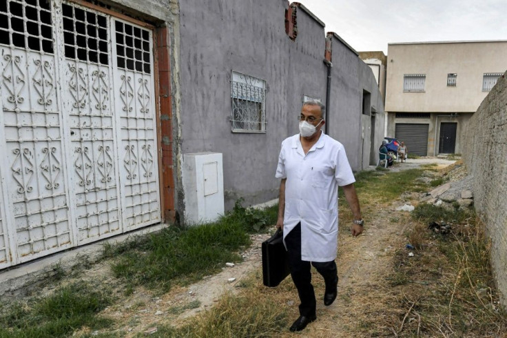 Tunisian physician Hichem Ouadi walks along a street in the Tunisian town of Bou Mhel during a house visit to a patient suffering from Covid-19