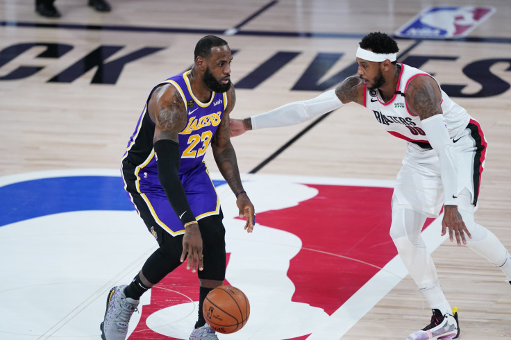 LeBron James #23 of the Los Angeles Lakers drives against Carmelo Anthony #00 of the Portland Trail Blazers