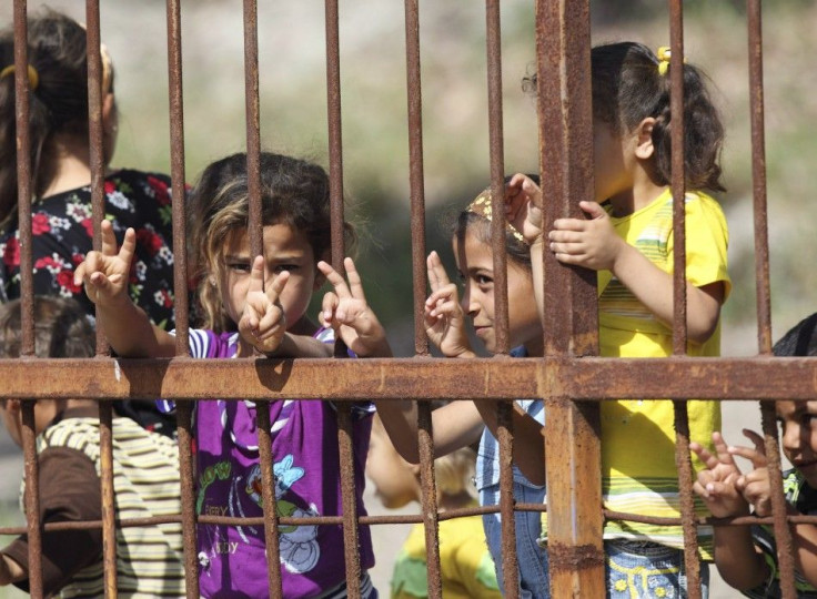 Syrian refugee children pose at a refugee camp in the Turkish border town of Yayladagi in Hatay province