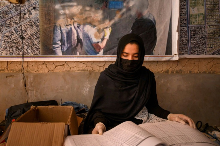 Midwife Qandi Gul registers patients at a mobile clinic for women and children near Lashkar Gah