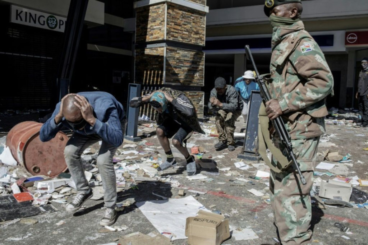 Police and troops detaining suspected looters at the Jabulani shopping mall in Soweto on Tuesday