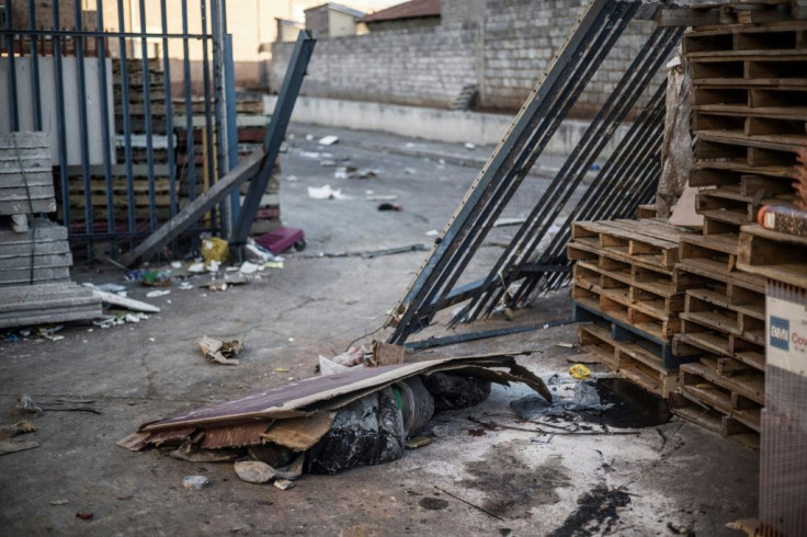 A body lies under a cardboard box at a ransacked mall in Vosloorus, on the outskirts of Johannesburg