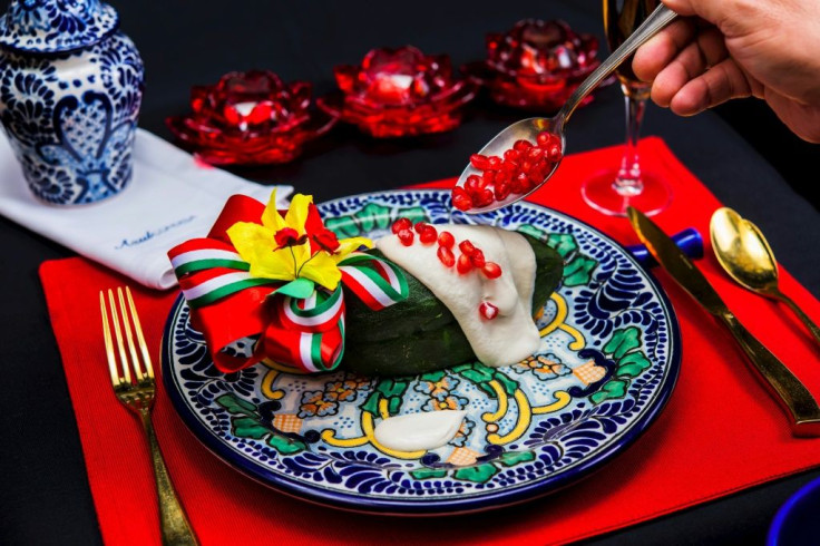 The traditional chile en nogada features poblano chile peppers bathed in creamy white sauce and topped with red pomegranate seeds