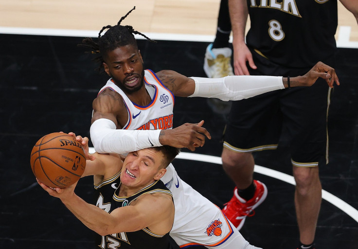 Bogdan Bogdanovic #13 of the Atlanta Hawks grabs a rebound against Nerlens Noel #3 of the New York Knicks