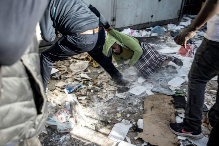 A woman, a suspected looter, is dragged out of a vandalised shop where she was caught by a group of community vigilantes