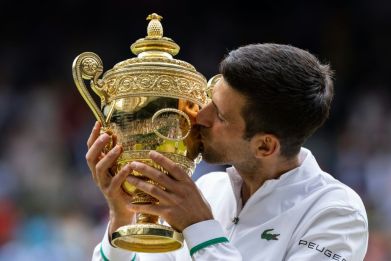 Champion again: Novak Djokovic kisses the winner's trophy after beating Italy's Matteo Berrettini in Sunday's Wimbledon final