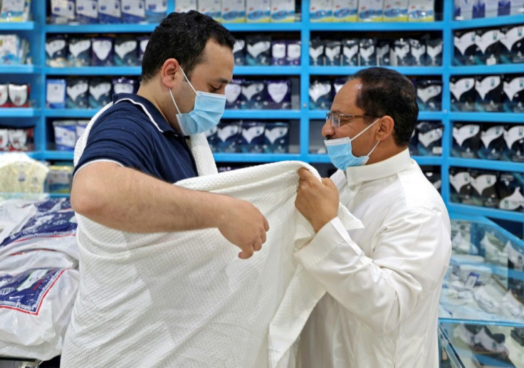 Egyptian Mohammed Alatar tries on the simple garment worn by pilgrims performing the hajj at a store in Saudi Arabia