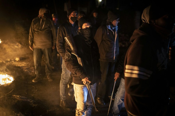 Members of the ethnic Indian community in Phoenix township stand guard at a roadblock
