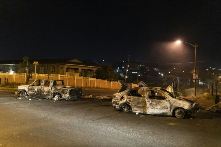 Violence: Burnt-out cars litter the township's streets