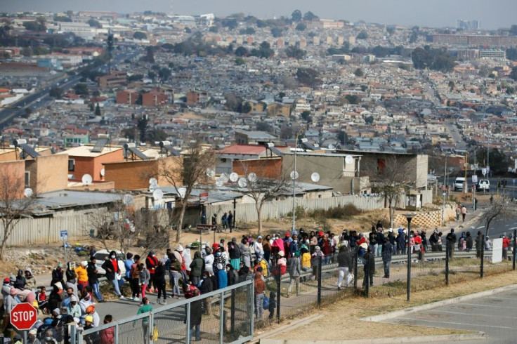 People queue outside the Alex Mall in Alexandra township near Johannesburg