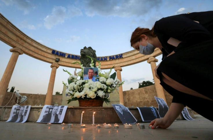 An Iraqi places a candle in a memorial to Hisham al-Hashemi in this July 11, 2020 photo