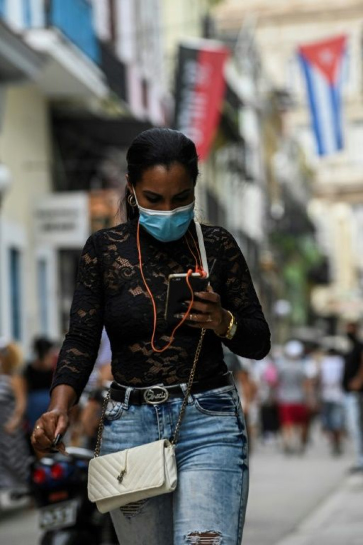 A woman uses her phone in a street of Havana, on July 14, 2021