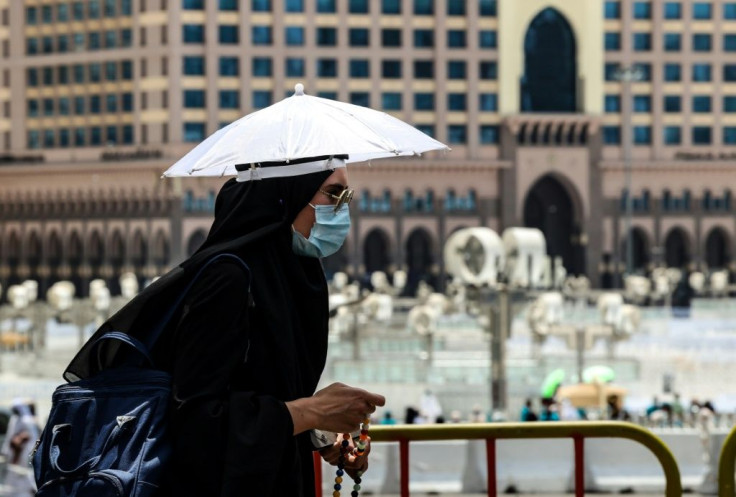 A pilgrim wears an umbrella hat to protect herself against the sun on the eve of the hajj
