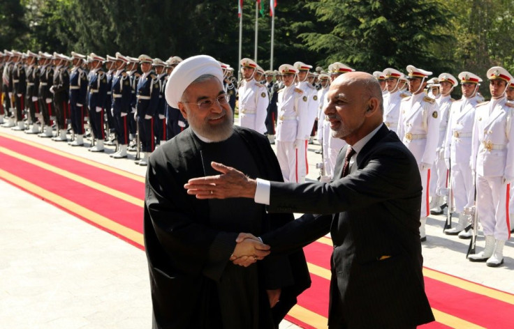 Iran's President Hassan Rouhani shakes hands with Afghan President Ashraf Ghani (R) during an official welcoming ceremony in Tehran in April 2015