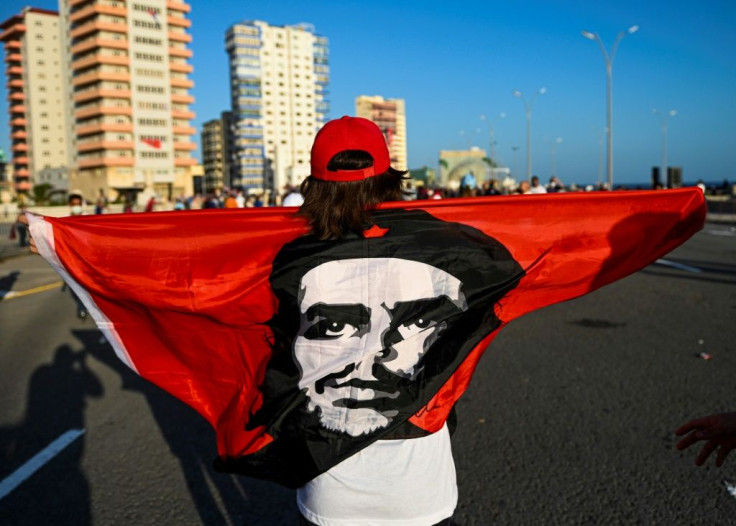 A woman holds a flag with the image of late Argentinian revolutionary Che Guevara in Havana, on July 17, 2021