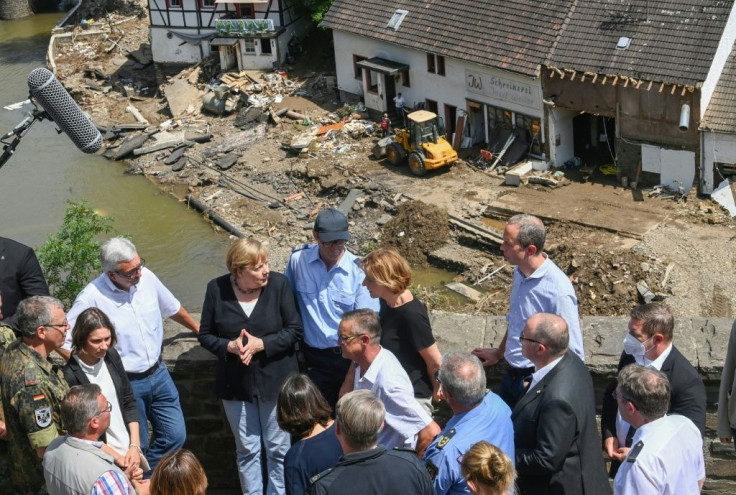 The veteran German leader listened to the accounts of residents where the swollen Ahr river swept away houses and left debris piled high in the streets