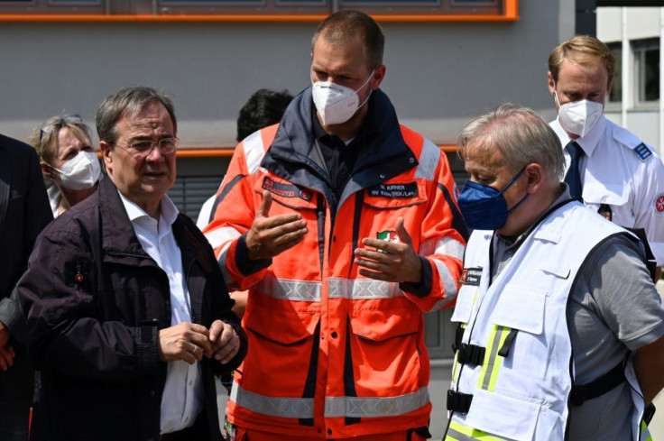 Armin Laschet (L) was spotted laughing during a visit to a flood-hit town