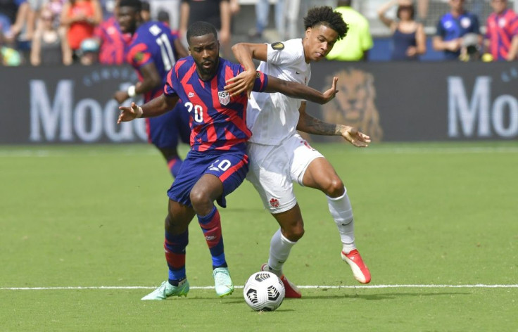 US defender Shaquell Moore, left, and Canada forward Tajon Buchanan battle for the ball during their CONCACAF Gold Cup match in Kansas City, Kansas