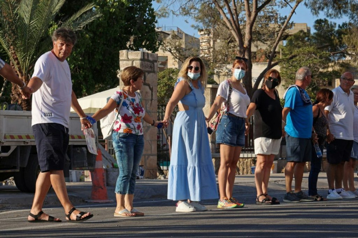 Nikos Karoullas, on the left, joins a human chain in the fenced-off area of Varosha in the self-proclaimed Turkish Republic of Northern Cyprus on July 16